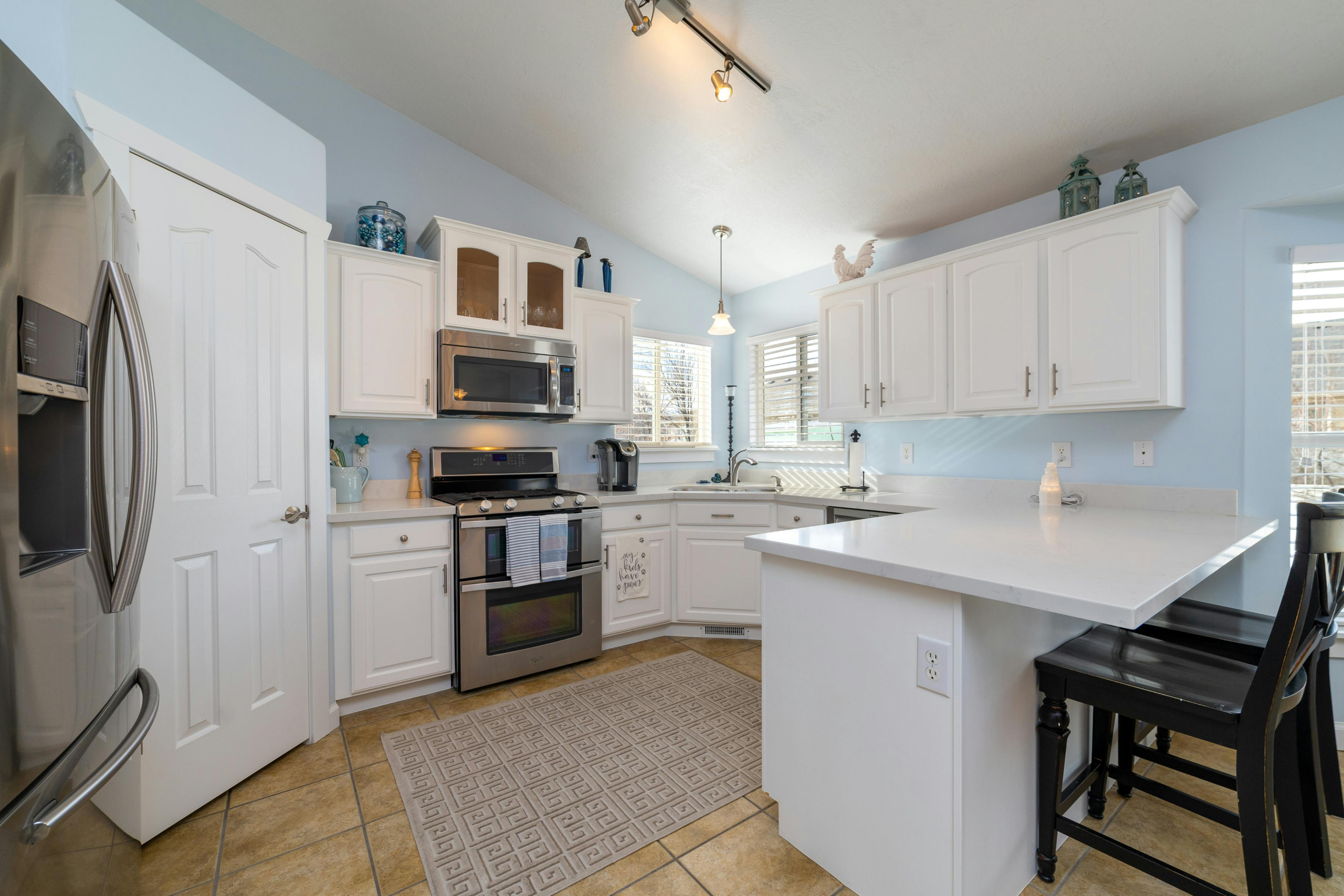Bright and airy kitchen interior featuring white cabinets and stainless steel appliances.